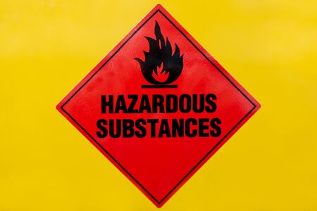 Red Hazardous Substances sign on a yellow cabinet front