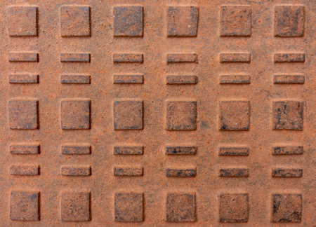 Rusty metal cover with square and equal signs embossed on it