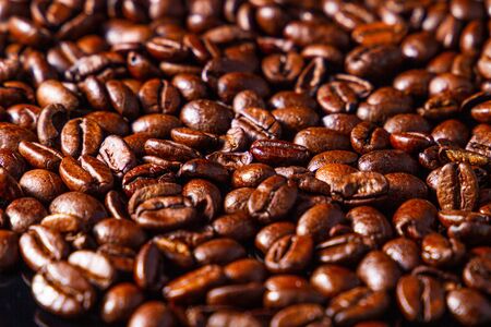Rich, dark coffee beans, roasted and cooked ready to grind.の写真素材