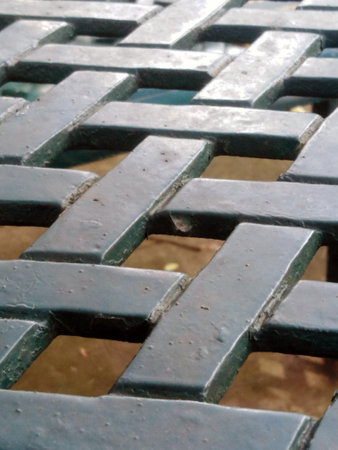 A detailed close-up of a weathered metal table surface showcasing a unique geometric pattern. Ideal...