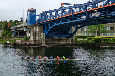 Seattle, USA April 23 2016: An 8 man sculling boat passes beneath the Fremont Bridge in Seattle,...
