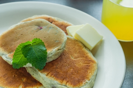 Pancakes on a plate with a glass of juiceの写真素材