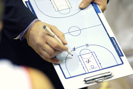 Basketball coach write tactics on plastic coaching boardの写真素材