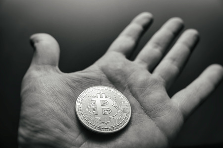 Hand holding bitcoin. Tonned vintage style photo.の写真素材