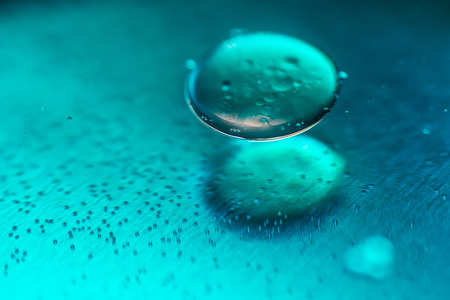 Colored oil drops and bubbles on a metal gear engine surface. Closeup photo.