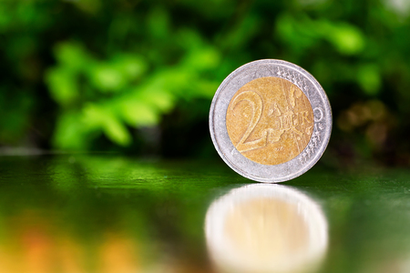 two euro coin closeup on silver and green background.の写真素材