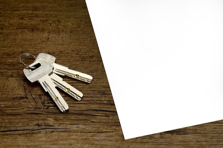 indenture or pact or contract blank for rent a apartment and 3 silver keys on wooden tableの写真素材
