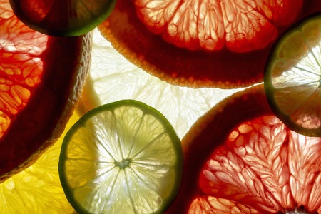 mixed colorful sliced fruits orange, lime, grapefruit, lemon. background back lightedの写真素材