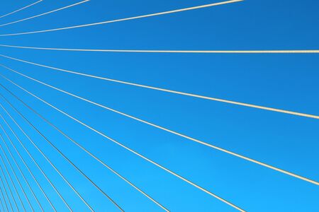 The wire rope fastened the bridge over the river with the background of a blue skyの写真素材