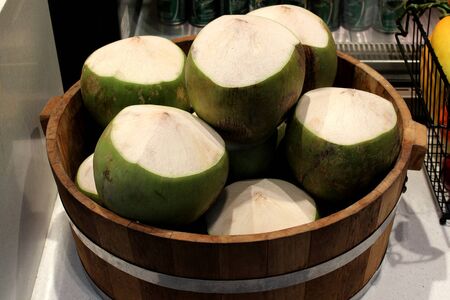 The coconuts are arranged in a wooden crate fore sale at a market in Bangkok, Thailand