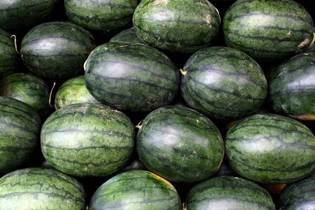 Watermelons are arranged orderly on the stall for sale at a market in Bangkok, Thailand