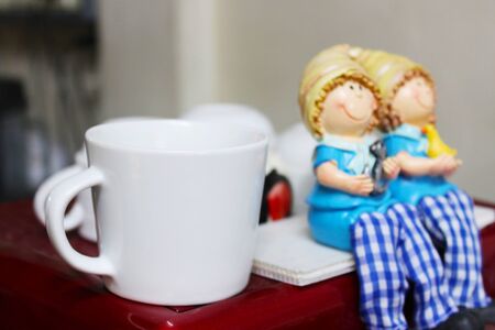 A white coffee cup placed on a red coffee makerの写真素材
