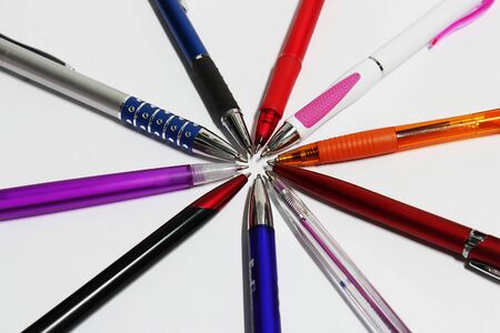 Ten colorful pens placed on a white paperの写真素材