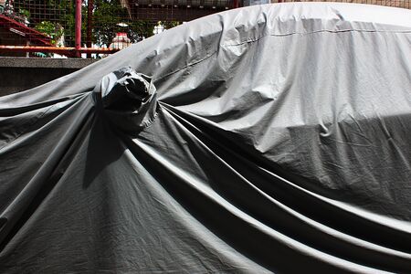 Gray canvas covers car that are not in use during the holidaysの写真素材