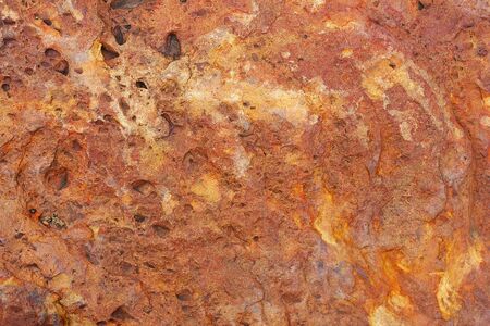 Pattern on red brown laterite stone as a background