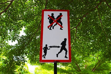 A sign of distancing 10 meters far from others while jogging in the park to prevent coronavirus 2019 (covid-19)の写真素材