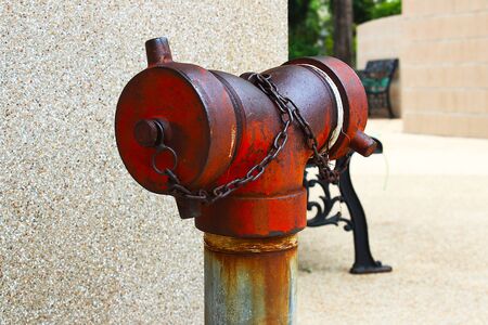 The old red fire hydrant placed in the park at Bangkok, Thailand