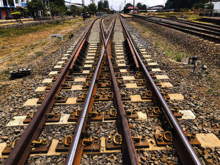 Two train tracks intersect in the area before reaching the train stationの写真素材