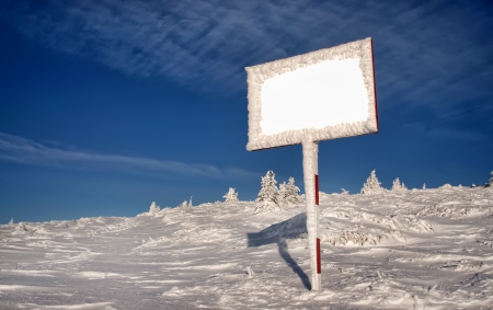 mountain winter landscape with empty billboard and blue skyの写真素材
