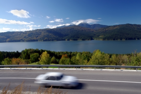 Moving car on road in autumn mountain landscapeの写真素材