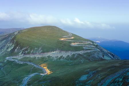curved road in mountains of Parang, Romania. Transalpina at night with car trails, long exposure.の写真素材