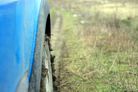 road with mud, side view of car. focus on the tireの写真素材