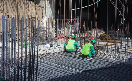 workers in construction industry. steel or iron bars on building