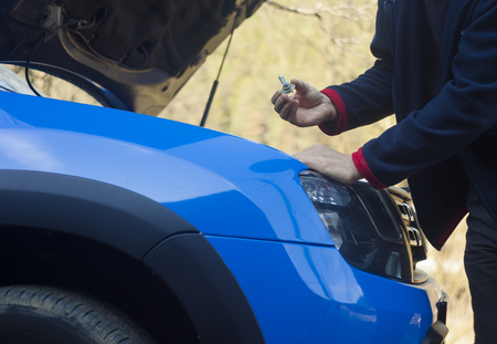 man hand changing light bulb on car headlightの写真素材