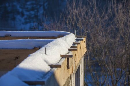 details of new building or house construction covered in winter snow