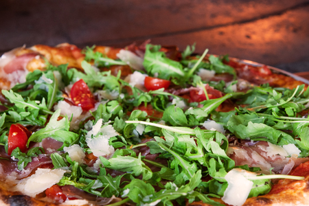 Close up pizza in firewood oven with flame behindの写真素材