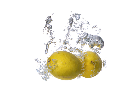 Fresh fruits, lemon falling in water splash, isolated on whiteの写真素材