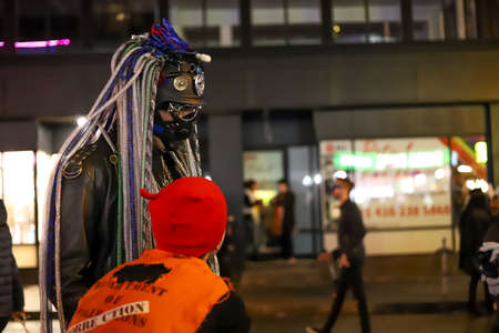 Halloween night carnival . Church street, people walking in different masks and costumes. Party,...