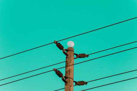 electricity post and white moon on blue sky - vintage retro effectの素材 [FY310200707221]