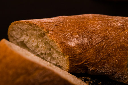 Close up of a loaf of ciabatta bread on black background