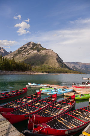 Summer vacation in the mountains. Active recreation - canoeing, kayaking - water sports. A tourist magnet on the lake Minnewanka, Banff National Park, Alberta, Canadaの写真素材