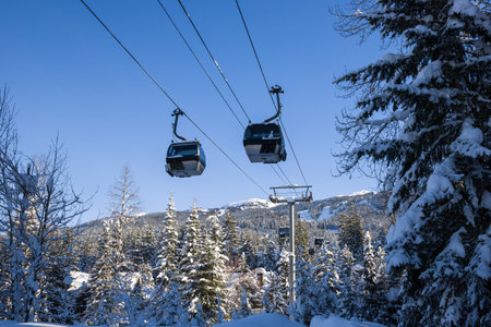Ski resort in the winter. The ski slope in winter. Ski lift in resort. Winter entertainment - ski and snowboarding. Evening Whistler Mountains, British Columbia, Canada.の写真素材
