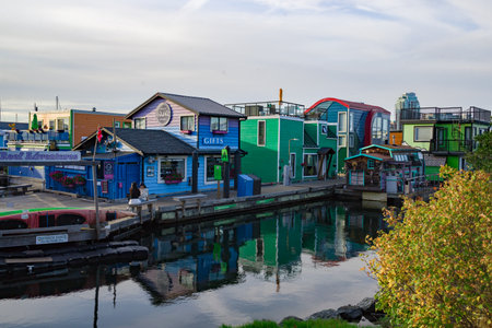 Colorful floating homes and modern buildings line the waterfront at Fisherman's Wharf in Victoria, BC, Canadaの写真素材