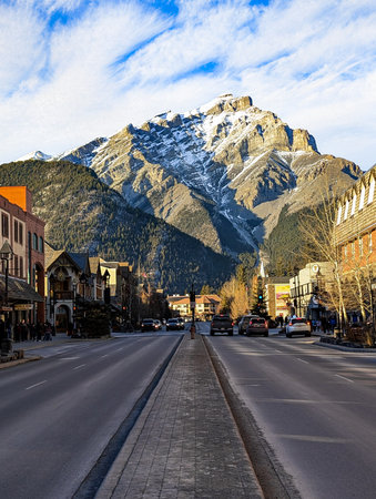 Banff downtown with city buildings, clear streets and beautiful mountains on backgroundの写真素材