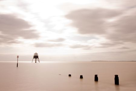 long exposure from the beach of a lighthouse at seaの写真素材