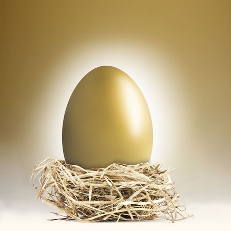 Big gold nest egg with a golden backgroundの写真素材