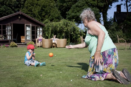 Elderly gran and little boy play catch in the gardenの写真素材