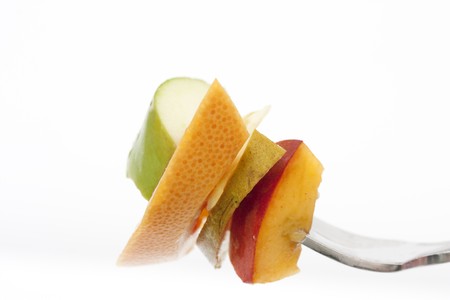 fruit on a fork isolated on a white backgroundの写真素材