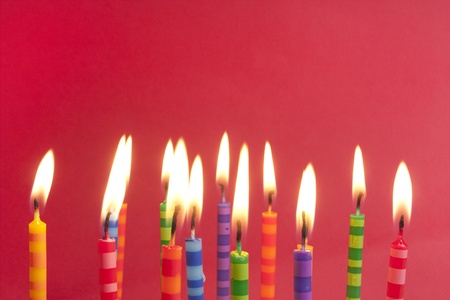 Candles alight on a red background, big group of striped designsの写真素材