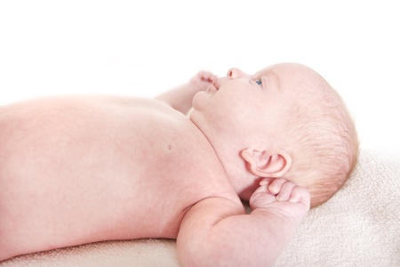 baby laying down on a white backgroundの写真素材