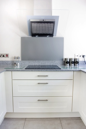modern kitchen with white units and extrator fan and hobの写真素材