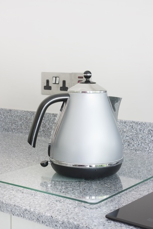 modern grey metal kettle stood on a granite worktopの写真素材