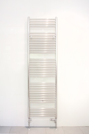 heated towel radiator hung on a bathroom wallの写真素材