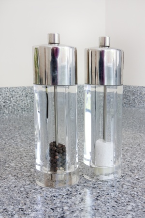 salt and pepper shakers on a granite worktopの写真素材