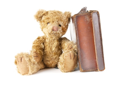 childs teddy bear sitting next to an old vintage suitcaseの写真素材