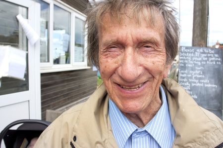retired man smiling outside wearing a jacket in springの写真素材